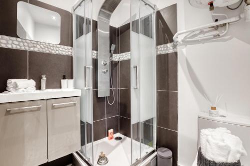 uma casa de banho com um chuveiro e uma porta de vidro em Le Baldaquin lac-d'Enghien paris CDG Stade de France em Montmorency