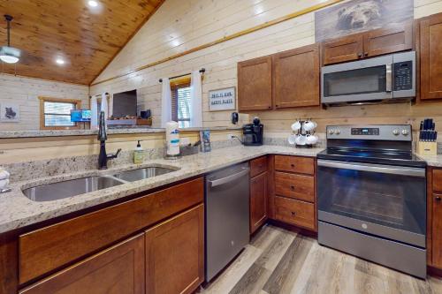 a kitchen with wooden cabinets and stainless steel appliances at Cozy Cardinal in Sevierville