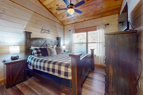 een slaapkamer met een bed en een plafondventilator bij Cozy Cardinal in Sevierville