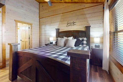 een slaapkamer met een bed met een houten muur bij Cozy Cardinal in Sevierville