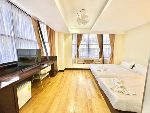 a hotel room with a bed and a desk and windows at ABC SO Hotel Bangkok in Bangkok