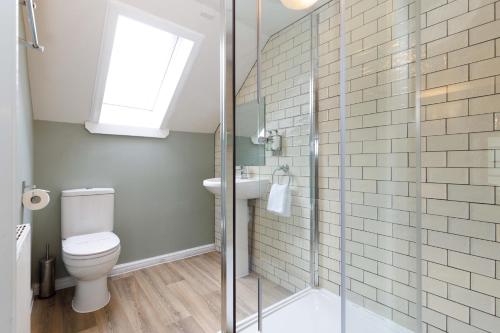 een badkamer met een toilet en een glazen douche bij Village Inn in Arrochar