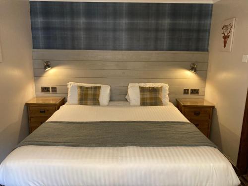 a bedroom with a large white bed with two pillows at Village Inn in Arrochar