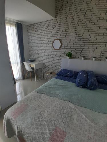 um quarto com uma cama e uma parede de tijolos em Niatmy em Kejayan