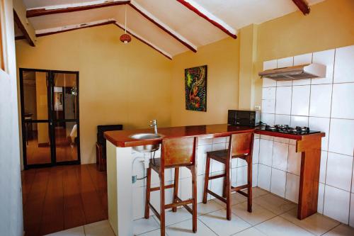 eine Küche mit einer Theke und Hockern in einem Zimmer in der Unterkunft La Patarashca in Tarapoto