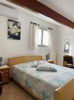 une chambre avec un lit et deux tables et une fenêtre dans l'établissement Les Cyprés, à Saintes-Maries-de-la-Mer