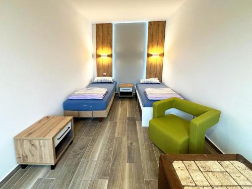a hospital room with two beds and a chair at Wesendorf Residenz Premium Lounge in Wesendorf