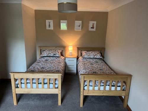 two beds in a small room with two beds at 4 Swallowholm Cottage in Langthwaite