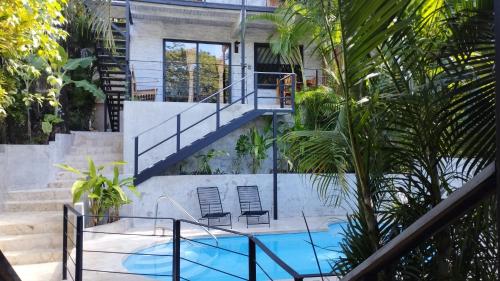 a house with a swimming pool and stairs at Hotel Raratonga in Santa Teresa Beach