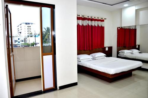 a bedroom with two beds and a mirror at Hotel Adarsh in Aurangabad