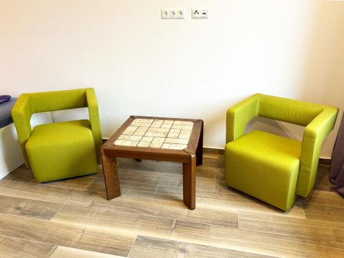 two green chairs and a table in a room at Wesendorf Residenz Premium Lounge in Wesendorf