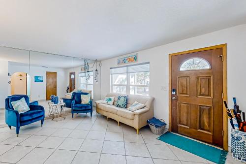 a living room with a couch and two blue chairs at Linda’s Lizard Landing in Port Orange