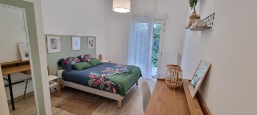 a bedroom with a bed and a table and a window at Résidence de Rueil-Malmaison in Rueil-Malmaison