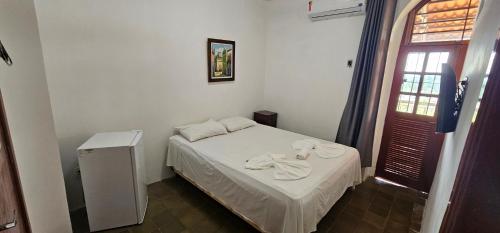 a small bedroom with a white bed and a window at Pousada Convento da Conceição in Olinda