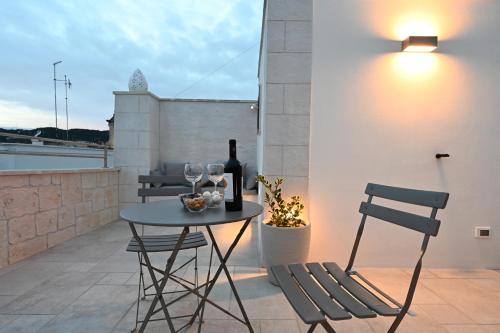 a table and chairs on a balcony with wine glasses at Suite Laurel SPA con idromassaggio in Fasano