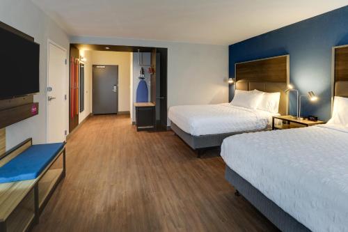 a hotel room with two beds and a flat screen tv at Tru By Hilton Leland Wilmington in Leland