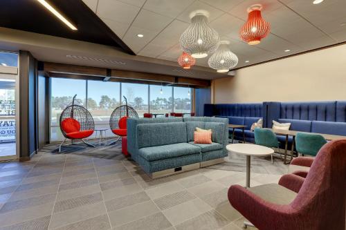 a waiting room with chairs and a couch and tables at Tru By Hilton Leland Wilmington in Leland