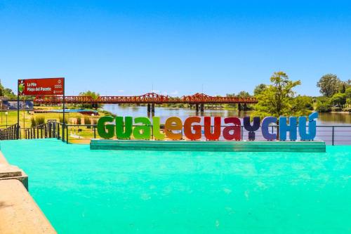 a sign for a water park with a bridge in the background at MeliGchu in Gualeguaychú