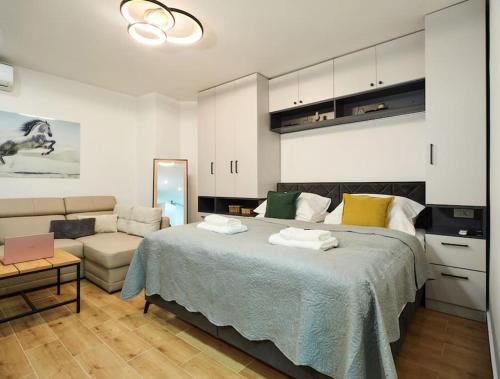 Market Studio by Irundo في زغرب: غرفة نوم بسرير كبير وأريكة