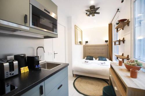 une cuisine avec un évier et une chambre avec un lit dans l'établissement Studio avec jacuzzi dans le 10e, à Paris