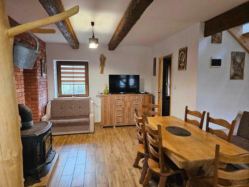 a living room with a table and a wood stove at Serce Beskidu Niskiego Myscowa in Krempna