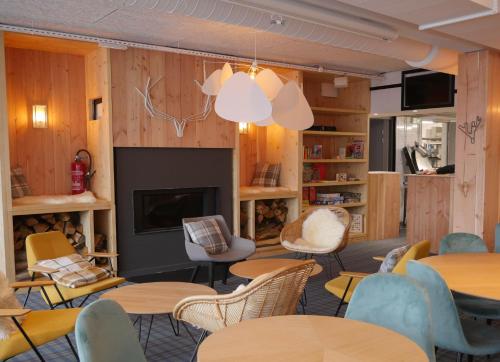 une chambre avec des tables, des chaises et une cheminée dans l'établissement Auberge de Piau, à Aragnouet