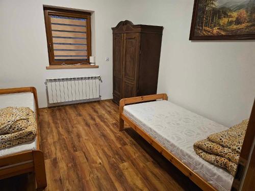 a bedroom with two beds and a dresser and a window at Serce Beskidu Niskiego Myscowa in Krempna