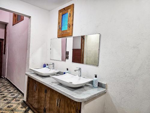 a bathroom with two sinks and two mirrors at DAR SABA in Rabat