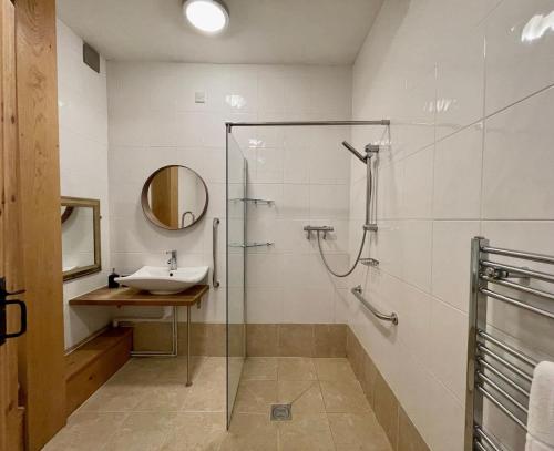 uma casa de banho com uma cabina de duche em vidro e um lavatório. em The Cart Lodge at Lee Wick Farm Cottages & Glamping em Saint Osyth