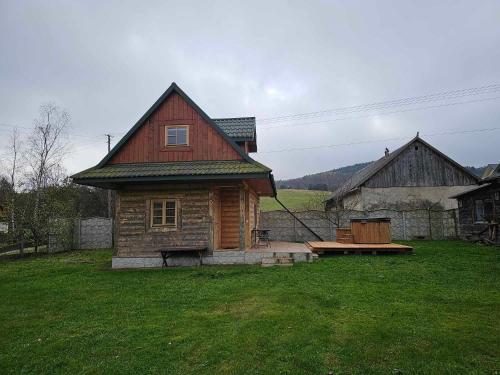 een klein houten huis in een grasveld bij Serce Beskidu Niskiego in Świątkowa Mała