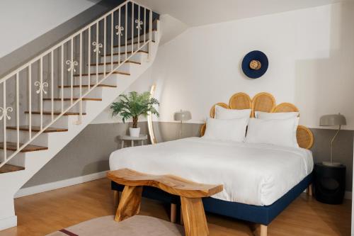 une chambre avec un lit et un escalier dans l'établissement Edgar Suites Saint-Augustin - Naples, à Paris