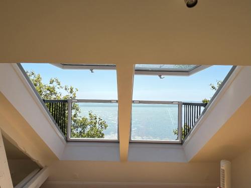 a room with a balcony with a view of the ocean at Villa Aziliz - Face Mer in Saint-Nazaire