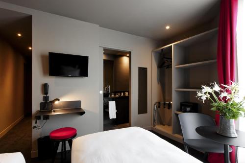 Habitación de hotel con cama, mesa y sillas en Hôtel Saint Marcel en París