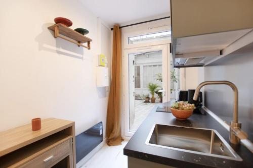 une cuisine avec un évier en acier inoxydable et une fenêtre dans l'établissement Luxury Suite w/ Jacuzzi - Rex / Montorgueil, à Paris