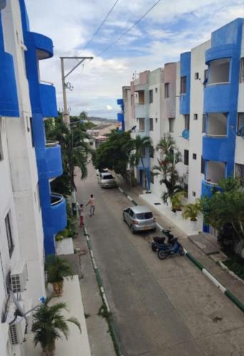 una calle de la ciudad con coches aparcados en el lateral de un edificio en Habitaciones El Mirador, en Cartagena de Indias