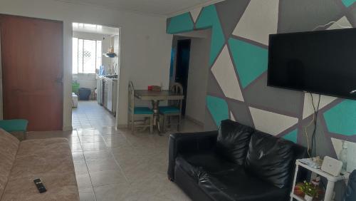 a living room with a couch and a flat screen tv at Habitaciones El Mirador in Cartagena de Indias