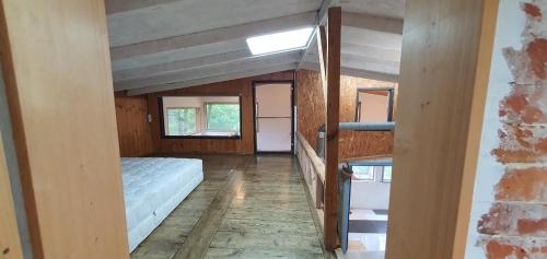 a bedroom with a bed and a staircase in a house at Tasha's Garden in Jeju