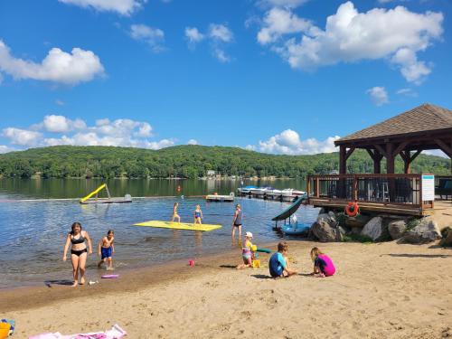 un gruppo di persone che giocano sulla sabbia su una spiaggia di Dayspring Cottages a Emsdale