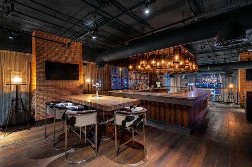 a bar with a counter and stools in a room at Hilton Dubai Al Habtoor City in Dubai