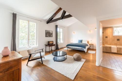 een woonkamer met een bed en een bank bij Loft Paris Expo Porte de Versailles in Malakoff