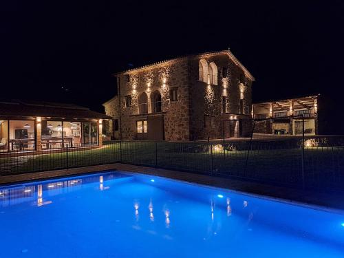 a swimming pool in front of a building at night at La Creu de la Pinya in Berga