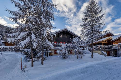a ski lodge with snow covered trees in front of it at Chalet Les Jeunes - Swiss Ski Chalet with amazing views 8pax in Riddes