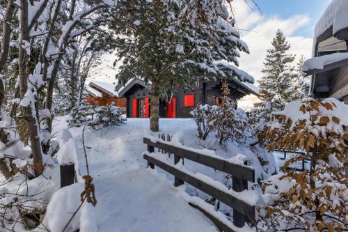 a house in the snow with red doors at Chalet Les Jeunes - Swiss Ski Chalet with amazing views 8pax in Riddes