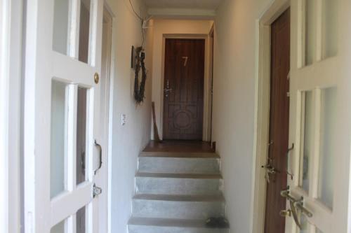 a hallway with a stairway with a brown door at KAJI HOME in Pātan