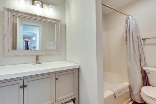 a bathroom with a sink and a toilet and a mirror at 4 Mi to Beach Wilmington Home with Gazebo Deck! in Wilmington
