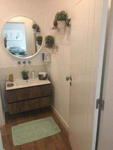 a bathroom with a sink and a mirror at Casa de Cece in Lagoa