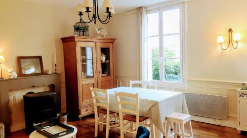 uma sala de jantar com uma mesa branca e cadeiras em Le Cottage de la Plage - 2ch, 2 SDB - Terrasse - Déco de charme - 500m plage em Cabourg