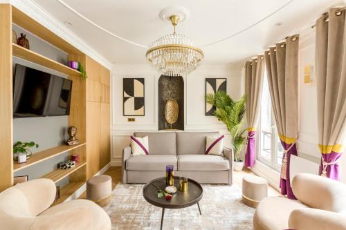sala de estar con sofá y lámpara de araña en Luxury 3 Bedroom & 3 Bathroom - Champs Elysees & Louvre en París