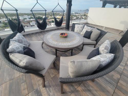 a balcony with wicker chairs and a table on a roof at Casa Sola Penthouse in Cabo San Lucas