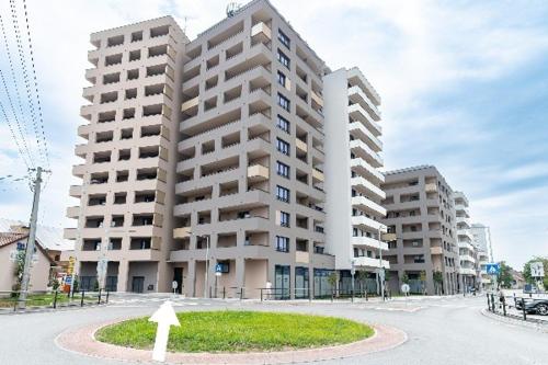 um grande edifício de apartamentos com uma seta em frente em Apartmán SoHo s private parking, 5 min peso do centra em Košice